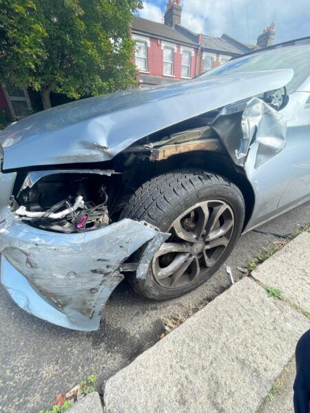A damaged car is parked on the side of the road