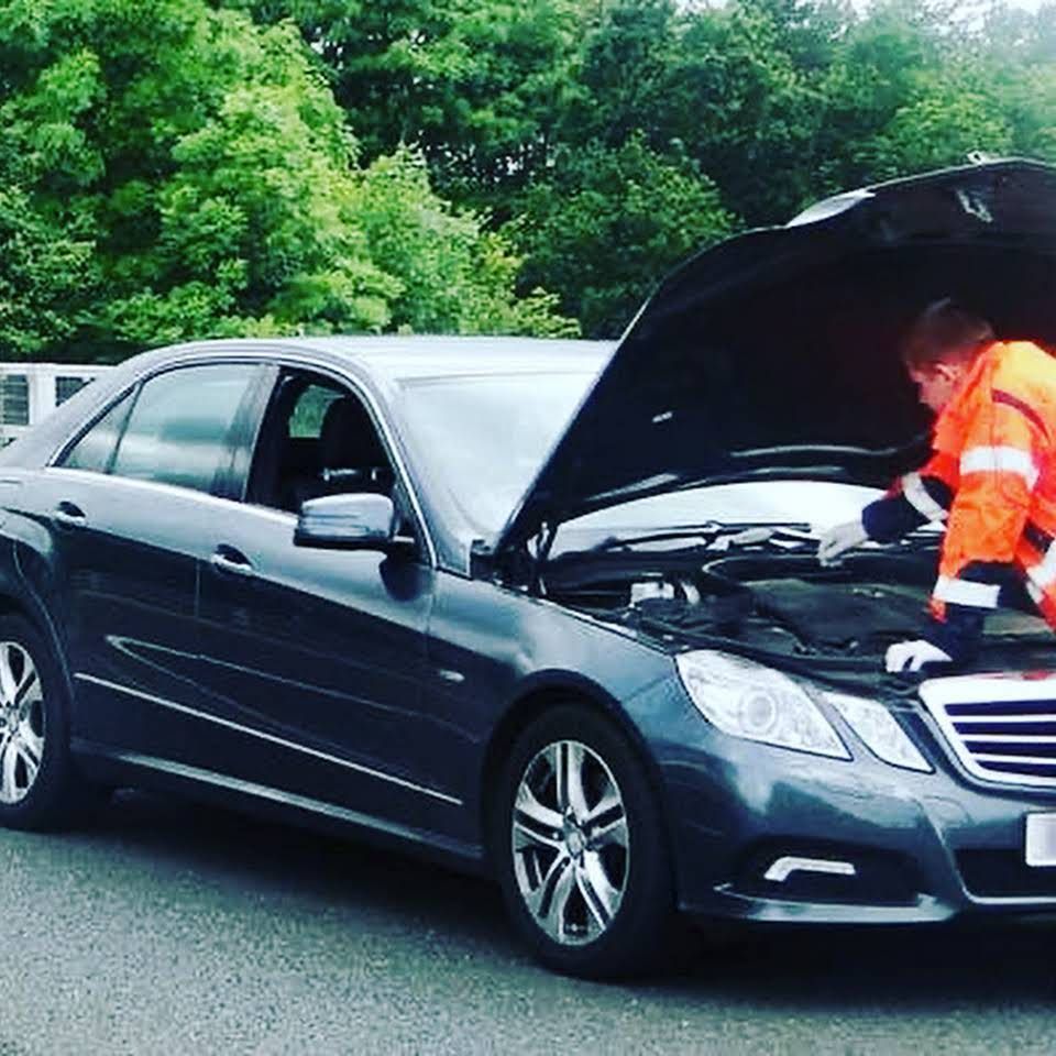 A man is working under the hood of a car