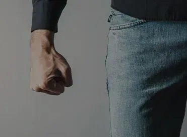 A Man Is Holding His Fist Up In The Air — Pleasanton, CA — Thompson • Garcia Law