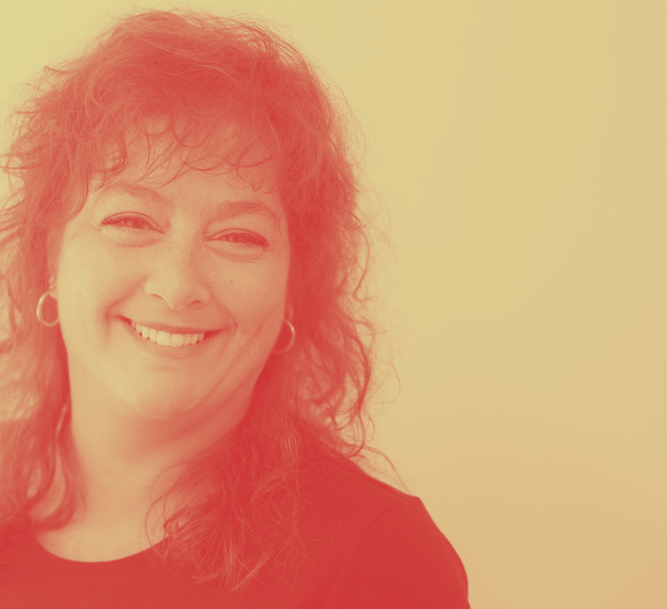A woman with red hair and earrings is smiling for the camera.