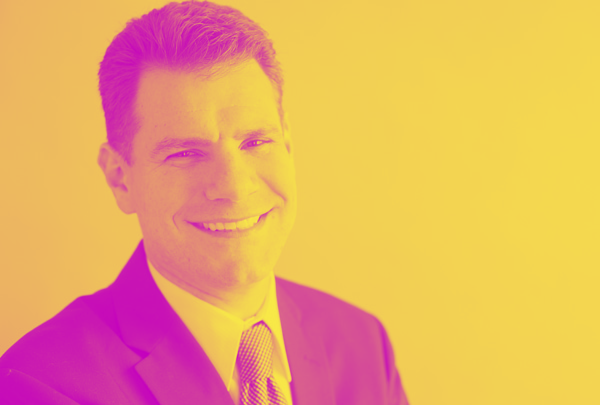 A man in a suit and tie is smiling