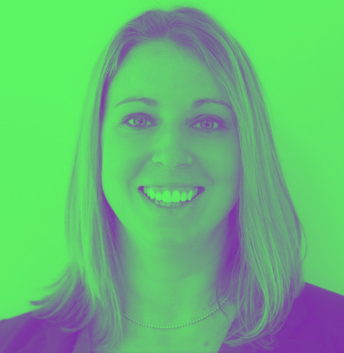 A woman is smiling in front of a green background.