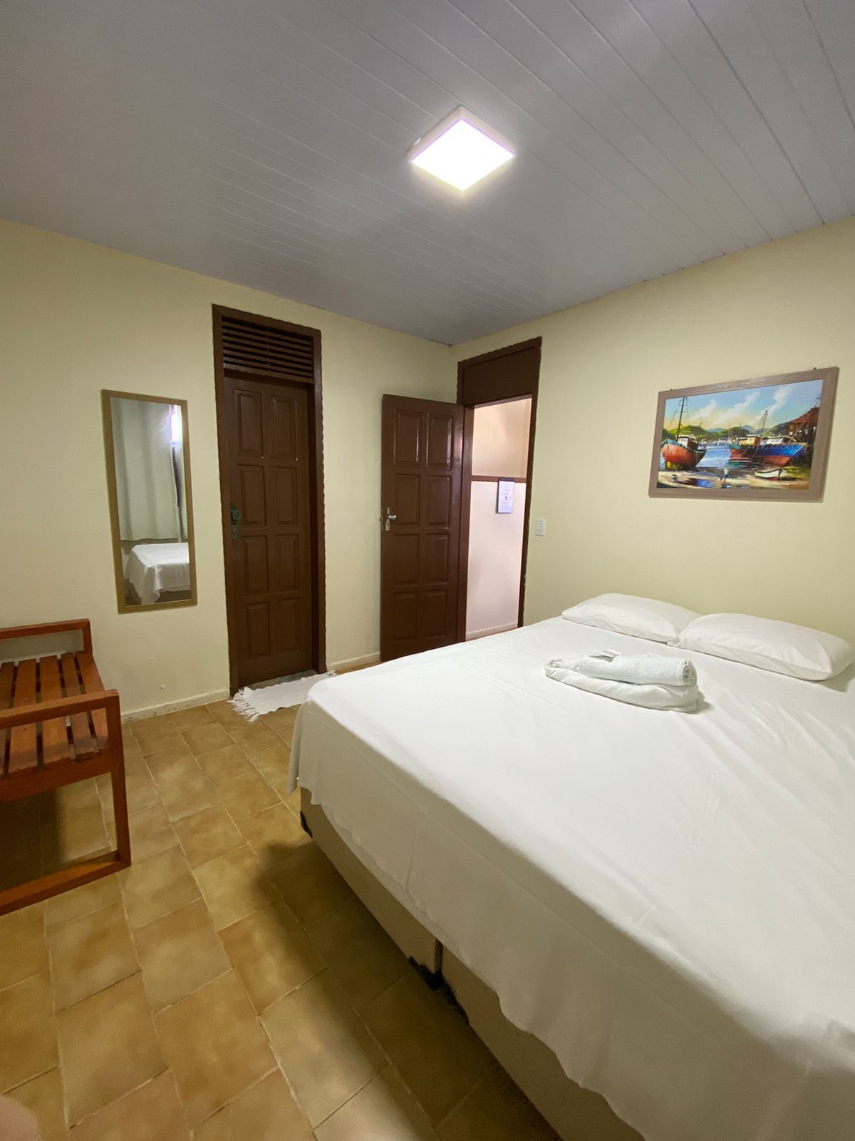 Há uma cama grande no meio do quarto.