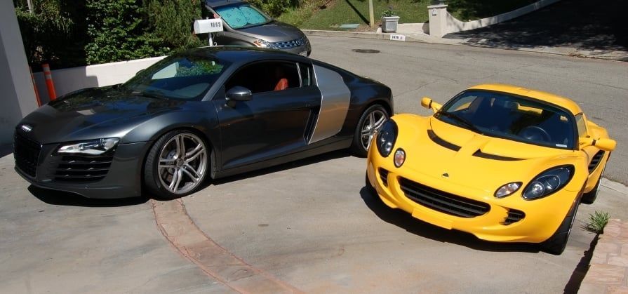 A black car and a yellow car are parked next to each other