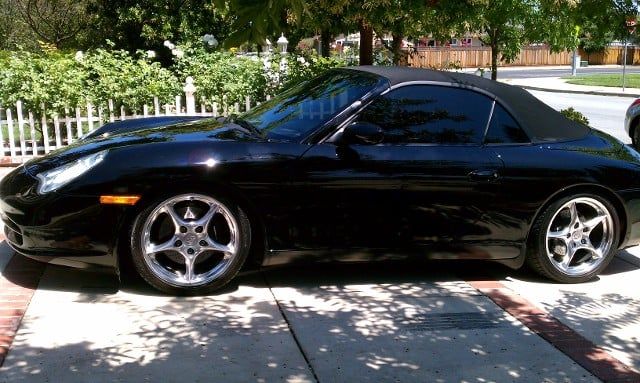 A black sports car is parked on the side of the road