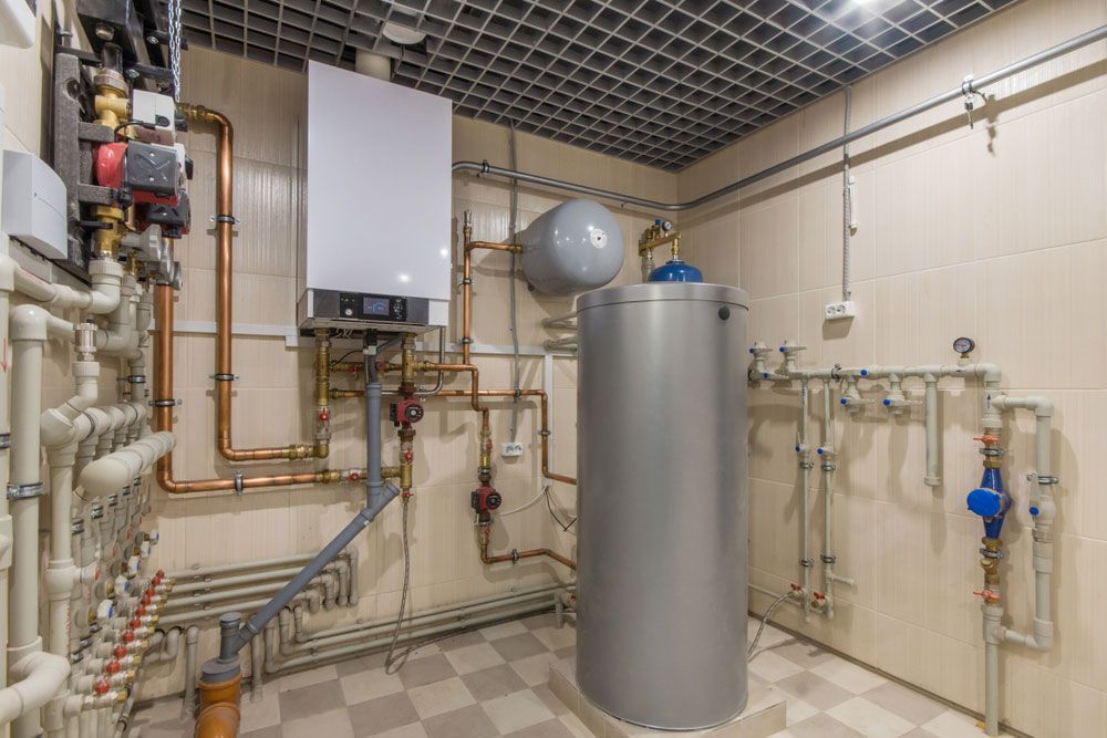 A Room With A Boiler And A Water Heater In It — No Risk Plumbing Kyogle Pty Ltd in Geneva, NSW