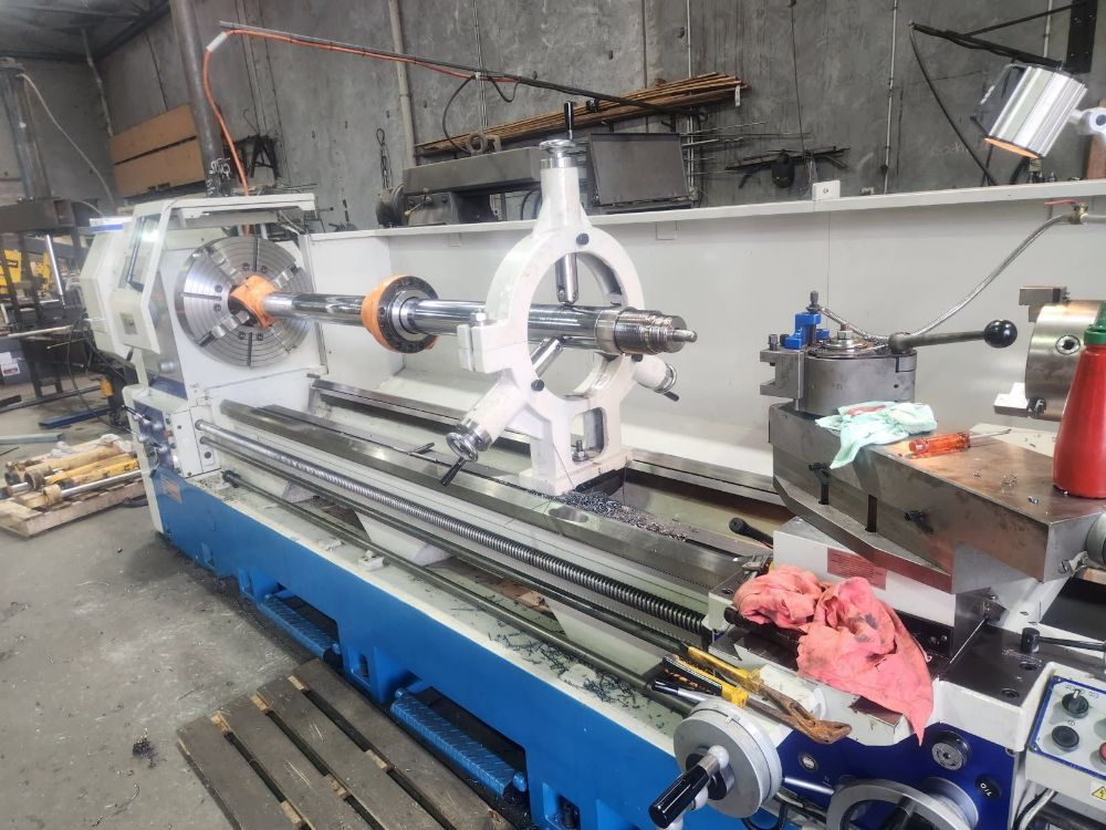 A Blue And White Lathe Is Sitting In A Warehouse — McLaren Engineering in Atherton, QLD