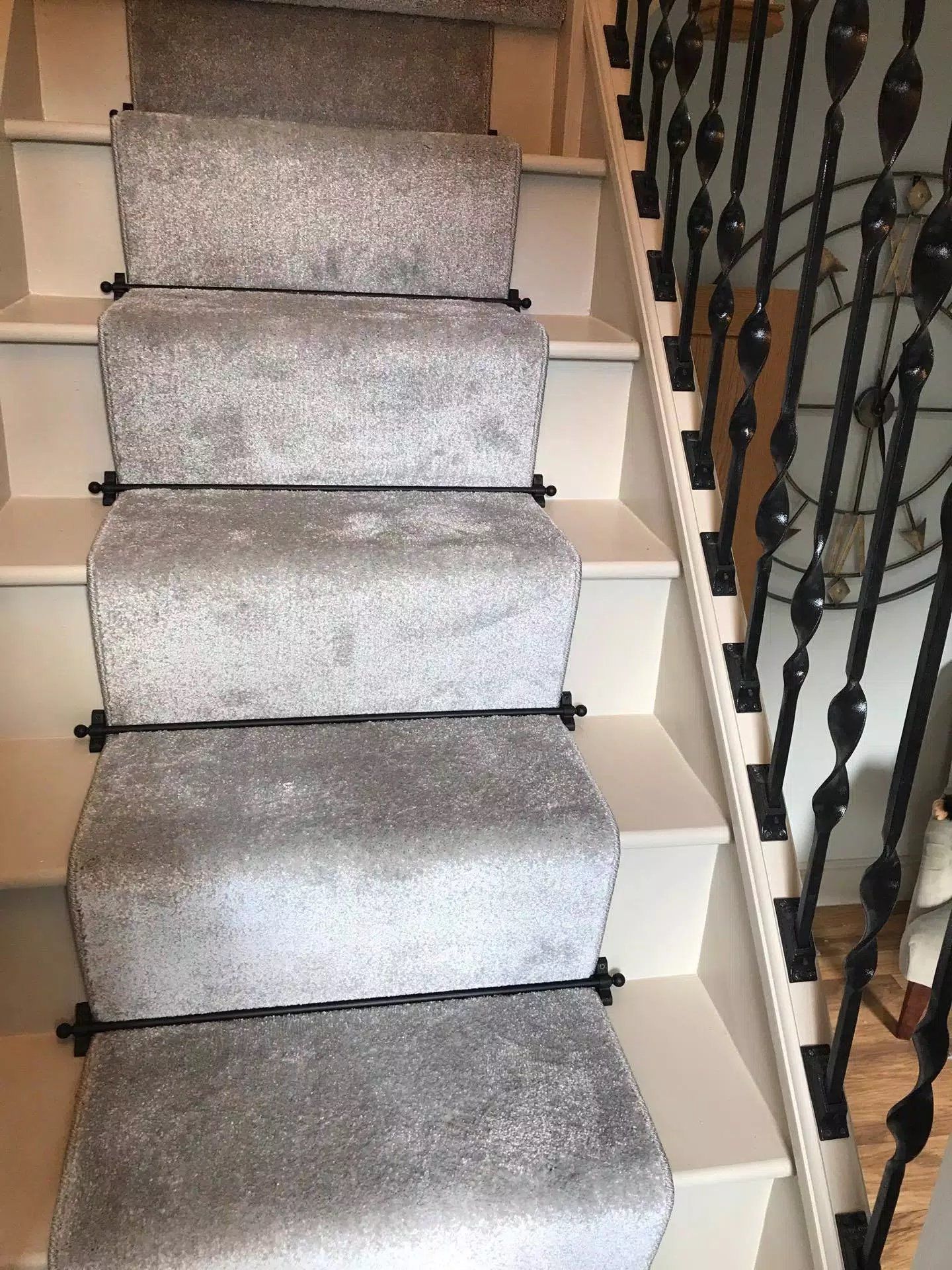 Newly painted and carpeted staircase with light grey tones and black brackets for a clean finish in York.