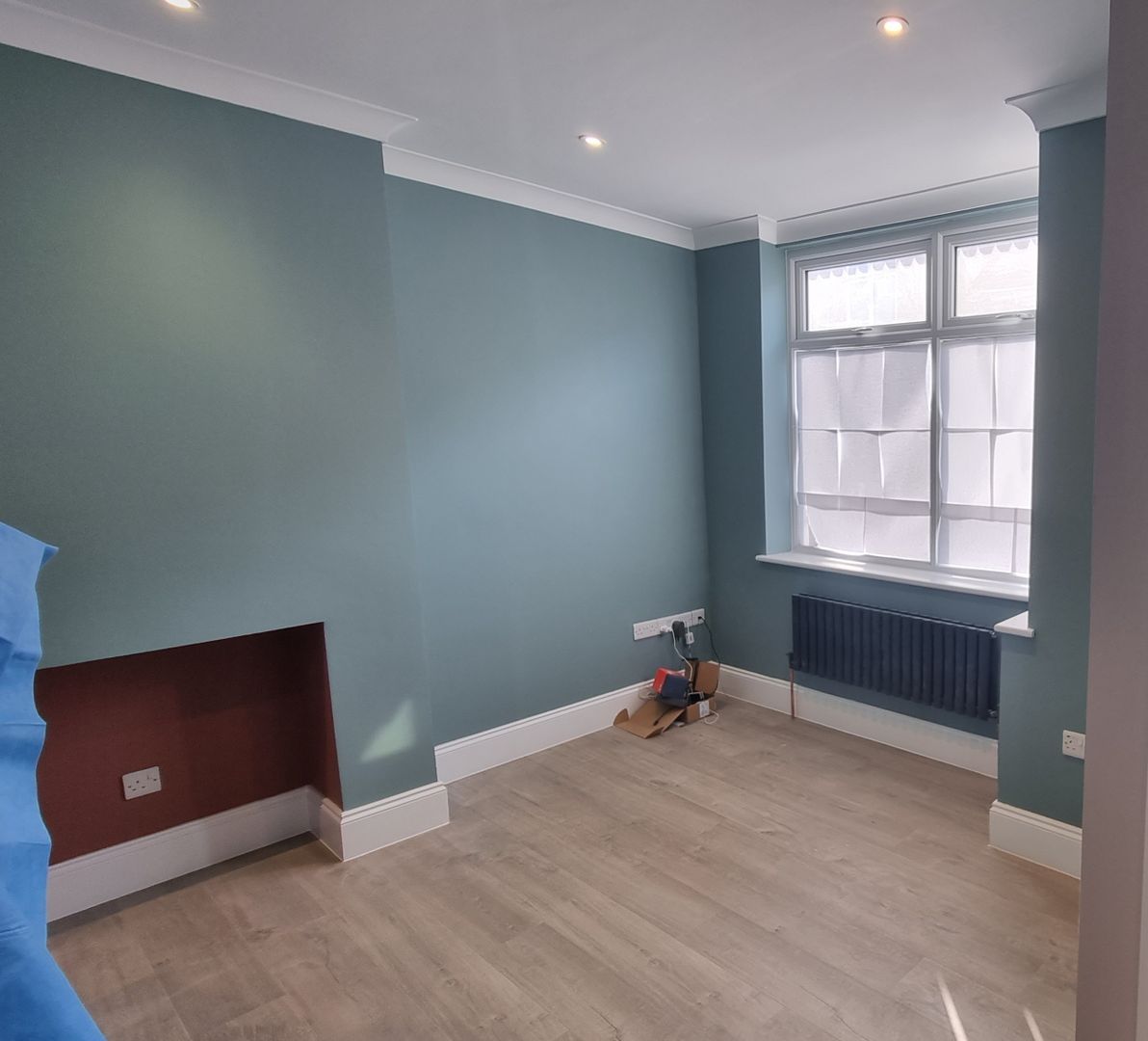 Renovated living room with soft blue walls and large windows bringing in natural light in York.
