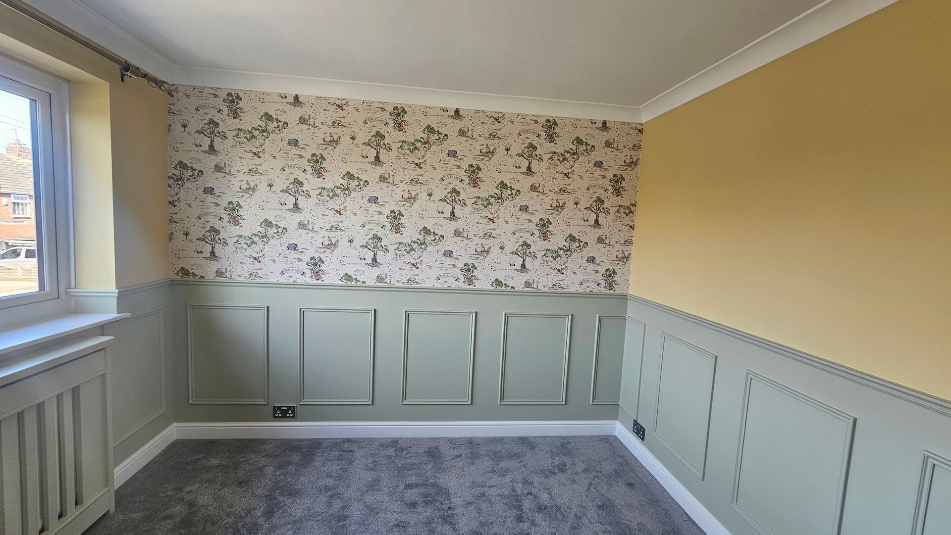 Beautifully decorated room with patterned wallpaper and green panelling in York.