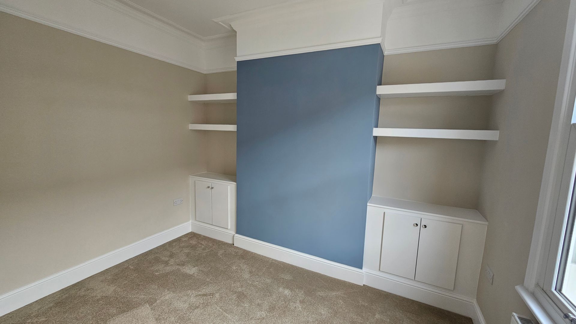 Renovated living room with cream walls and a blue feature wall in York.