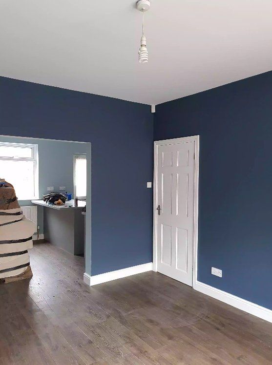 Room with bold navy walls, white door, and natural lighting in York.