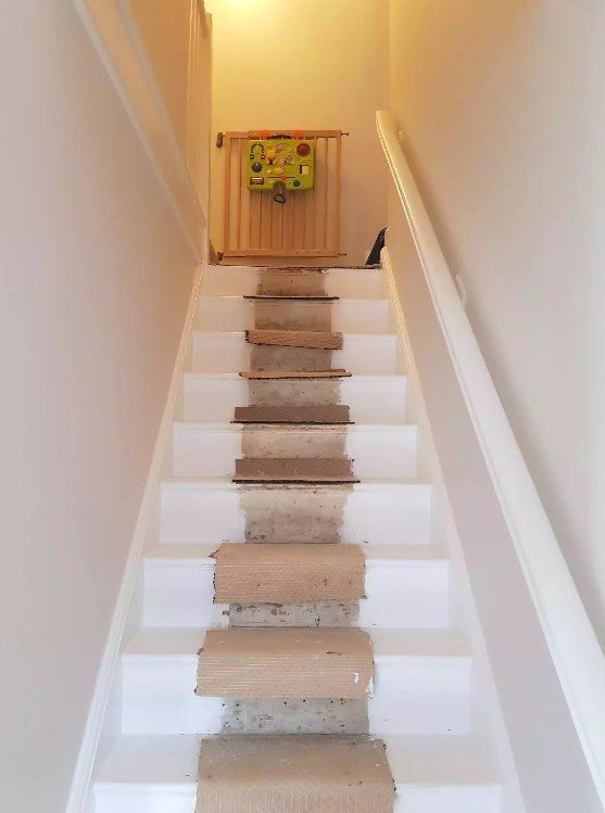 Renovation of staircase with partially stripped wooden steps and fresh white paint in York.
