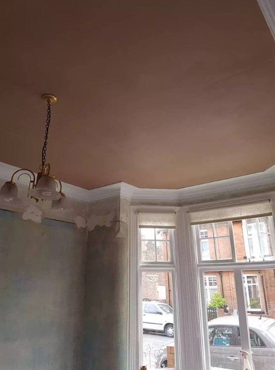 Renovation in progress with a newly plastered ceiling and elegant chandelier in York.