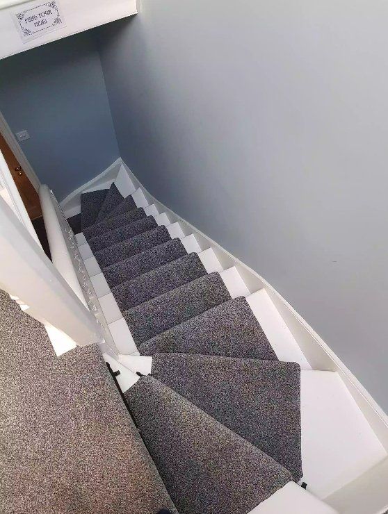 Staircase during carpet installation with plastic coverings to protect the work in York.