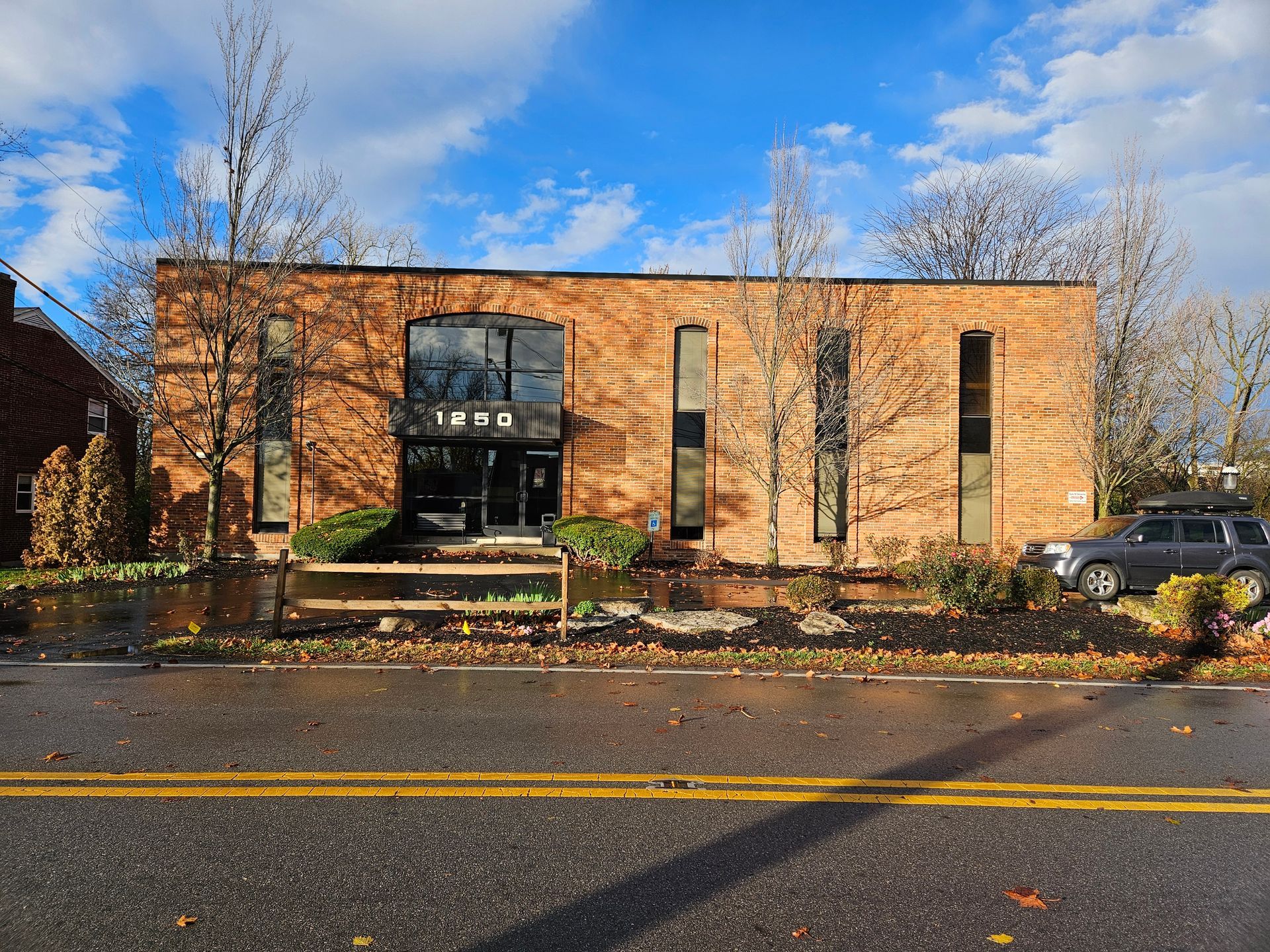 A large brick building with a car parked in front of it.