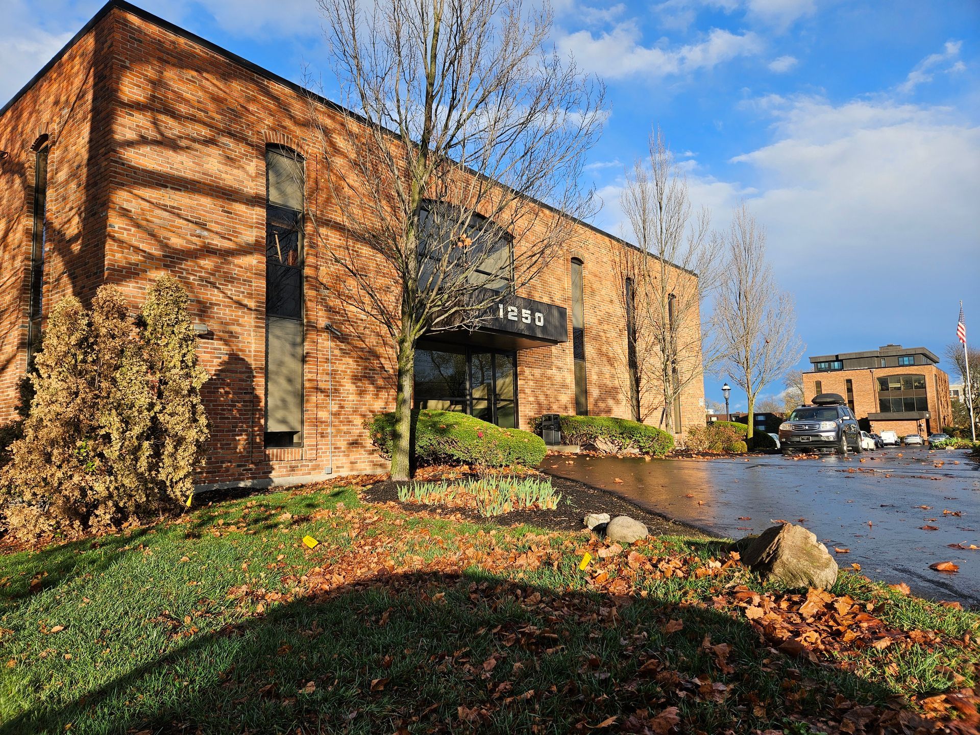 A large brick building with a parking lot in front of it.