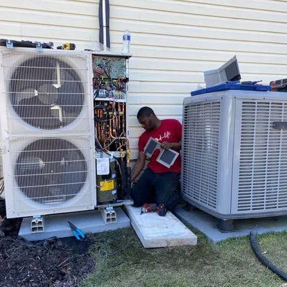 A man is working on an air conditioner outside of a house.