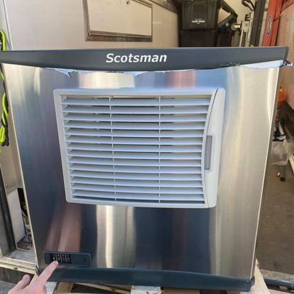 A person is pointing at a stainless steel air conditioner.