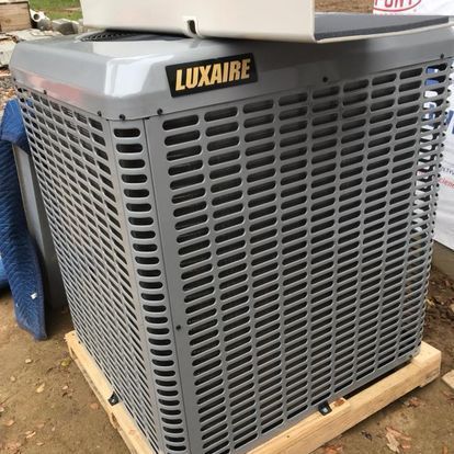 A luxaire air conditioner is sitting on top of a wooden pallet.