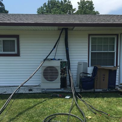 A white house with a hose hanging from the side of it.