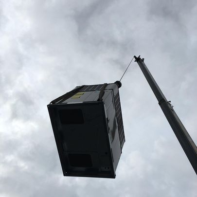 A box is being lifted by a crane in the sky