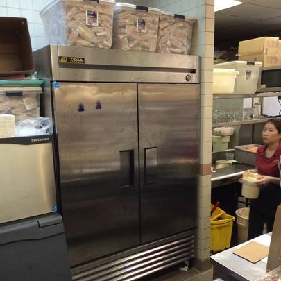 A stainless steel refrigerator in a restaurant kitchen