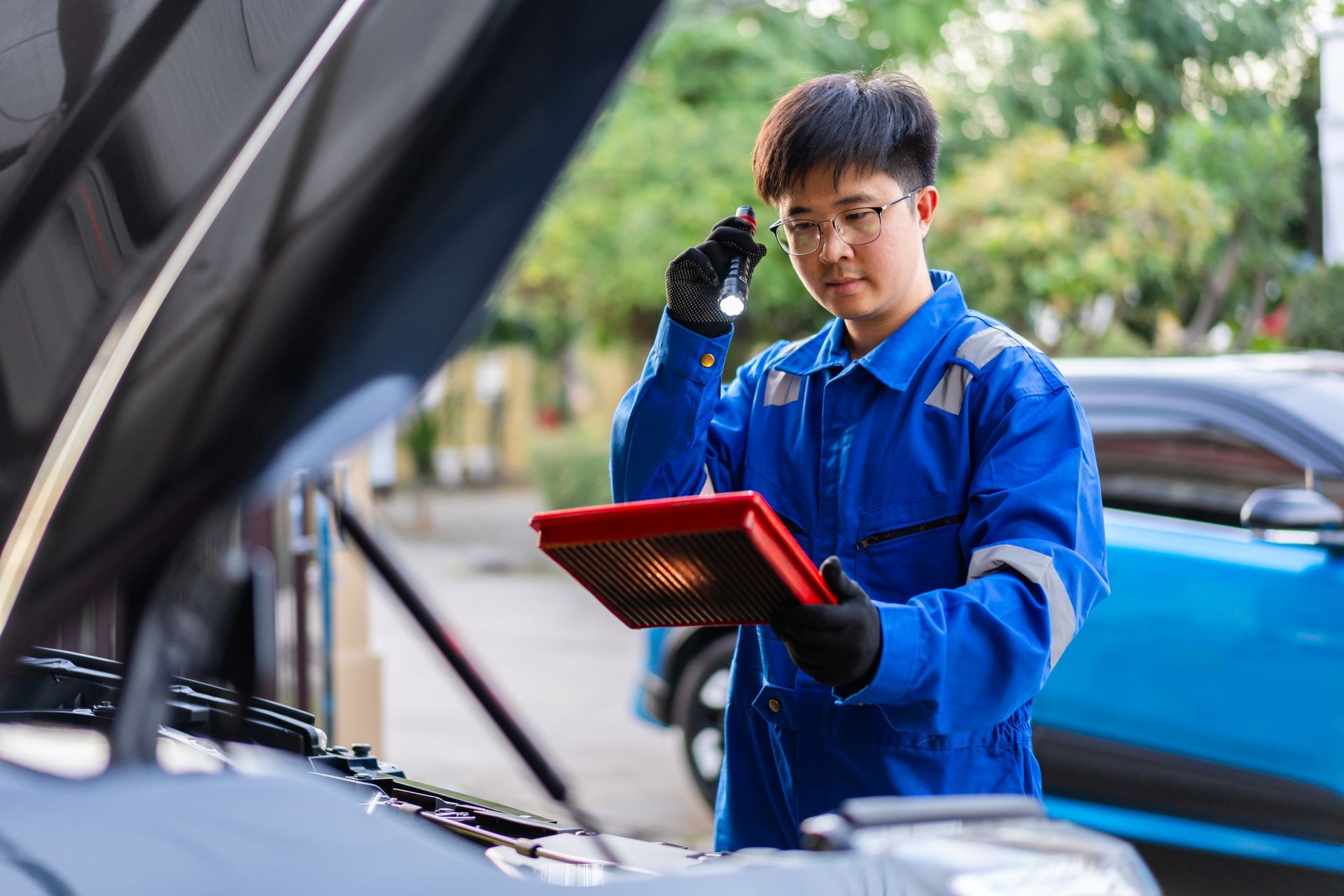 Trucker wearing warm clothes is checking the brake air hose coil.