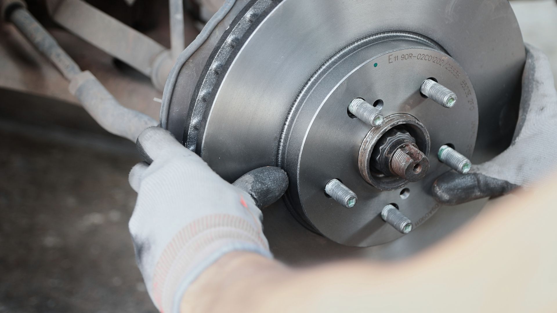 Zoomed view of new car brake parts including wheel hub and disc brake, showcasing auto components. Zoomed view of new car brake parts including wheel hub and disc brake, showcasing auto components.