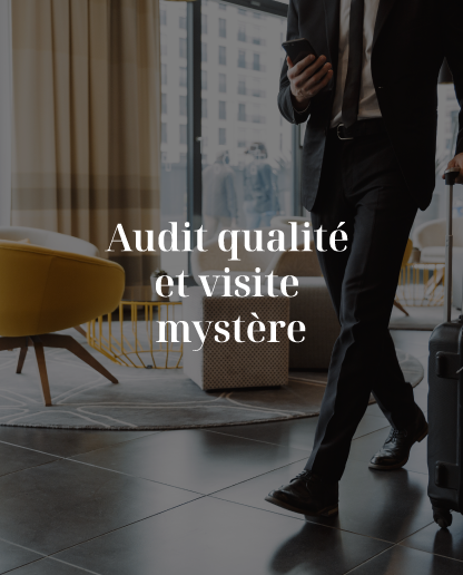 Un homme en costume marche avec une valise et regarde son téléphone