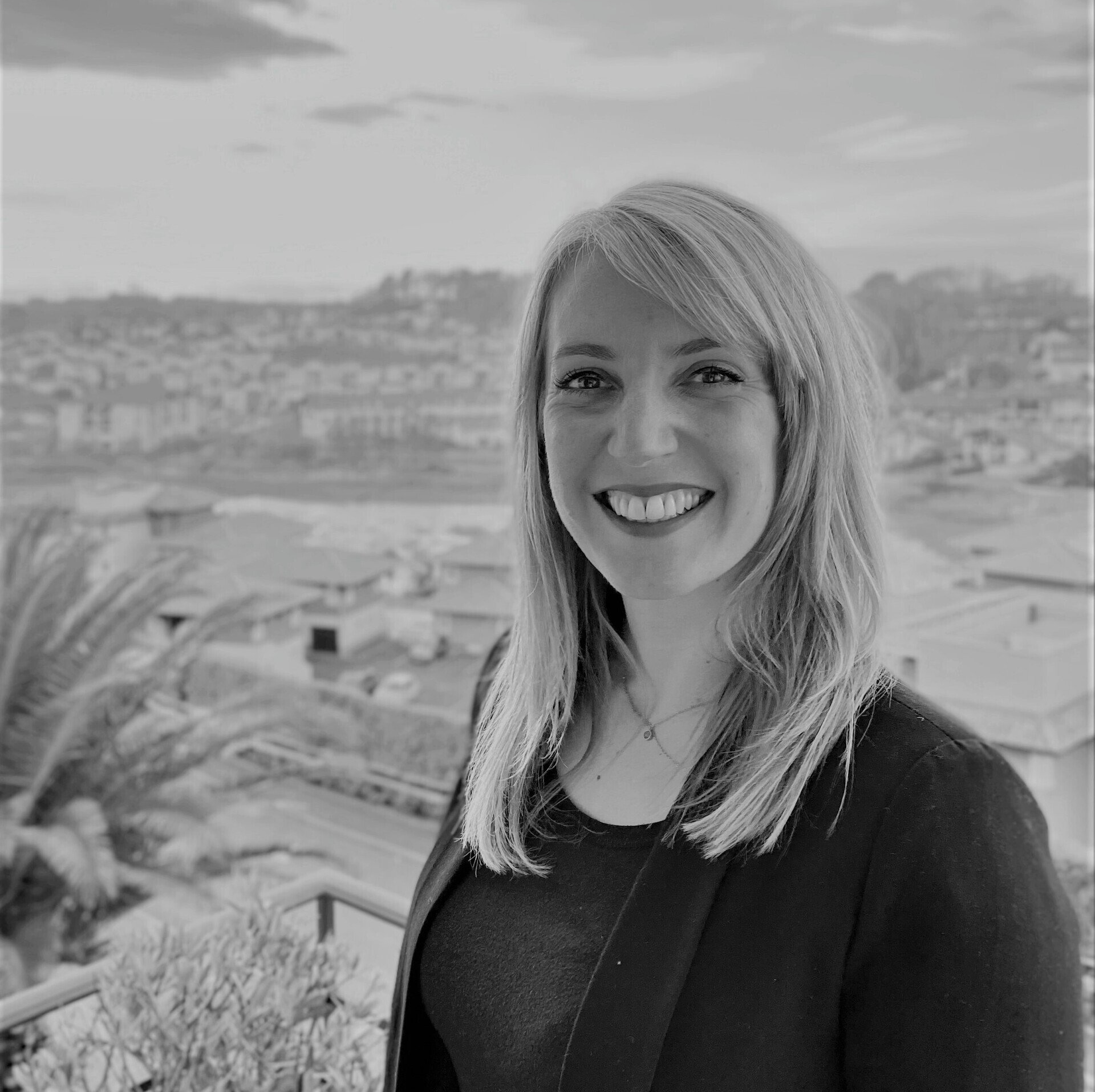 A woman is smiling in a black and white photo.