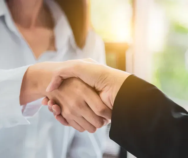 Un homme et une femme se serrent la main, gros plan de leurs mains.