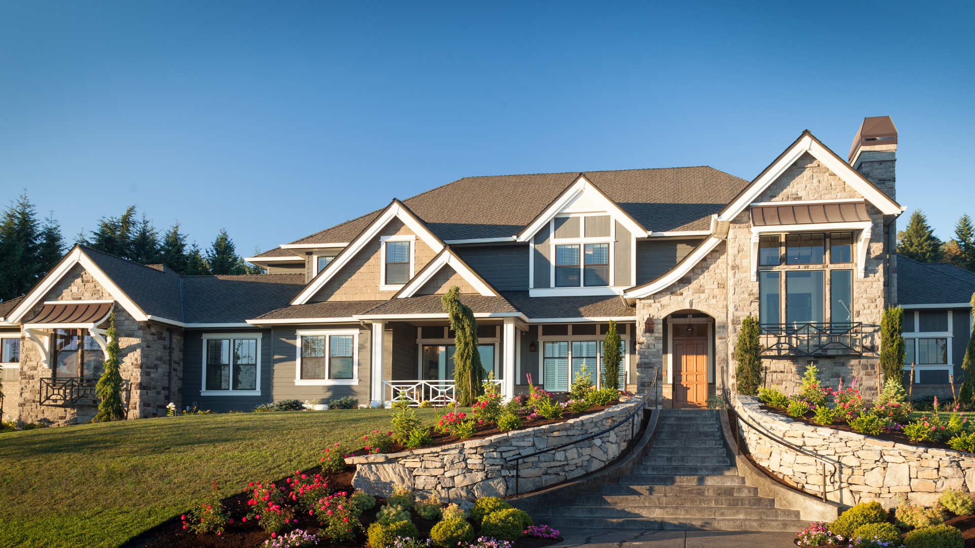 A large house with a stone wall in front of it