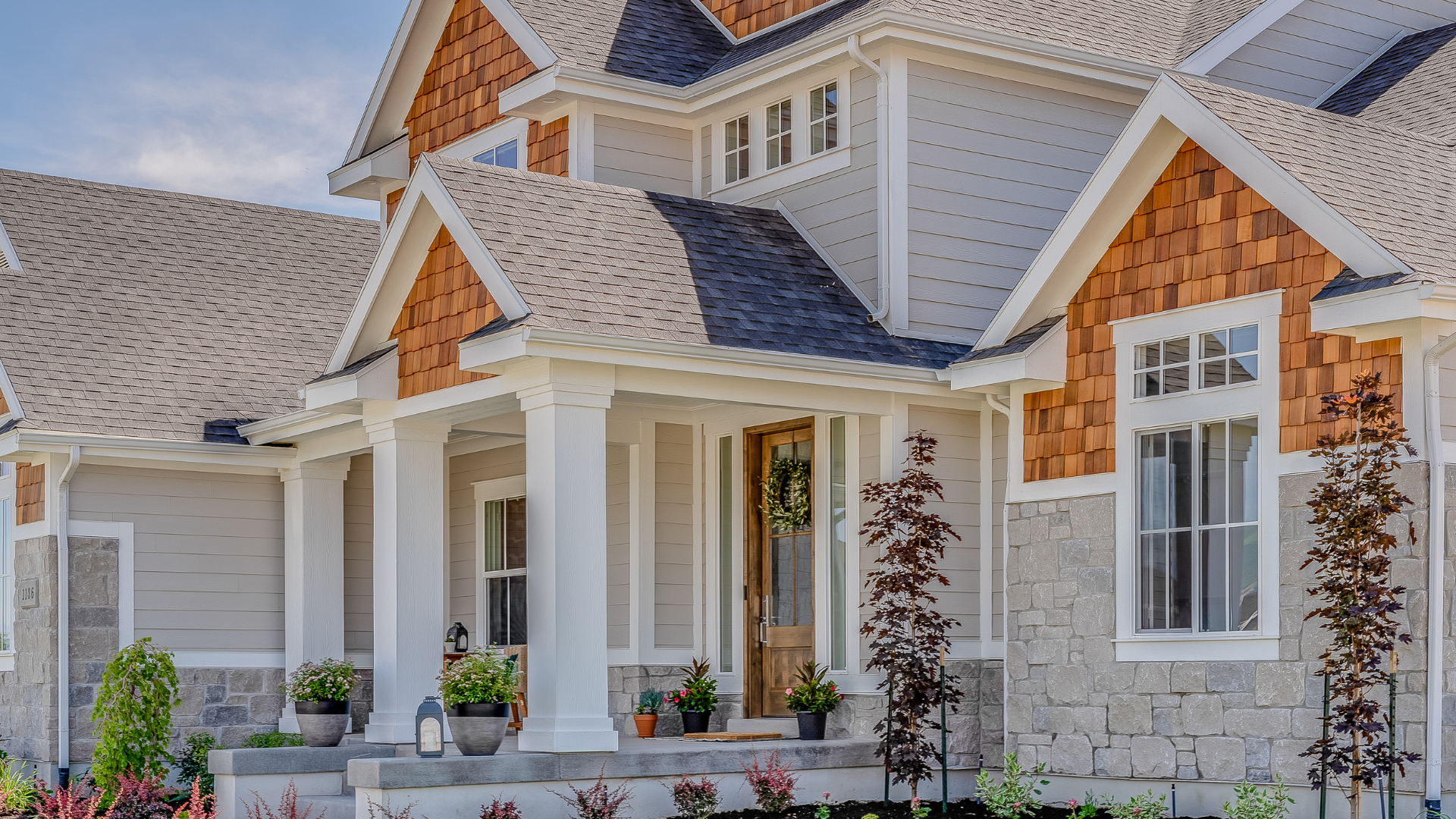 A large house with a large porch and a roof.