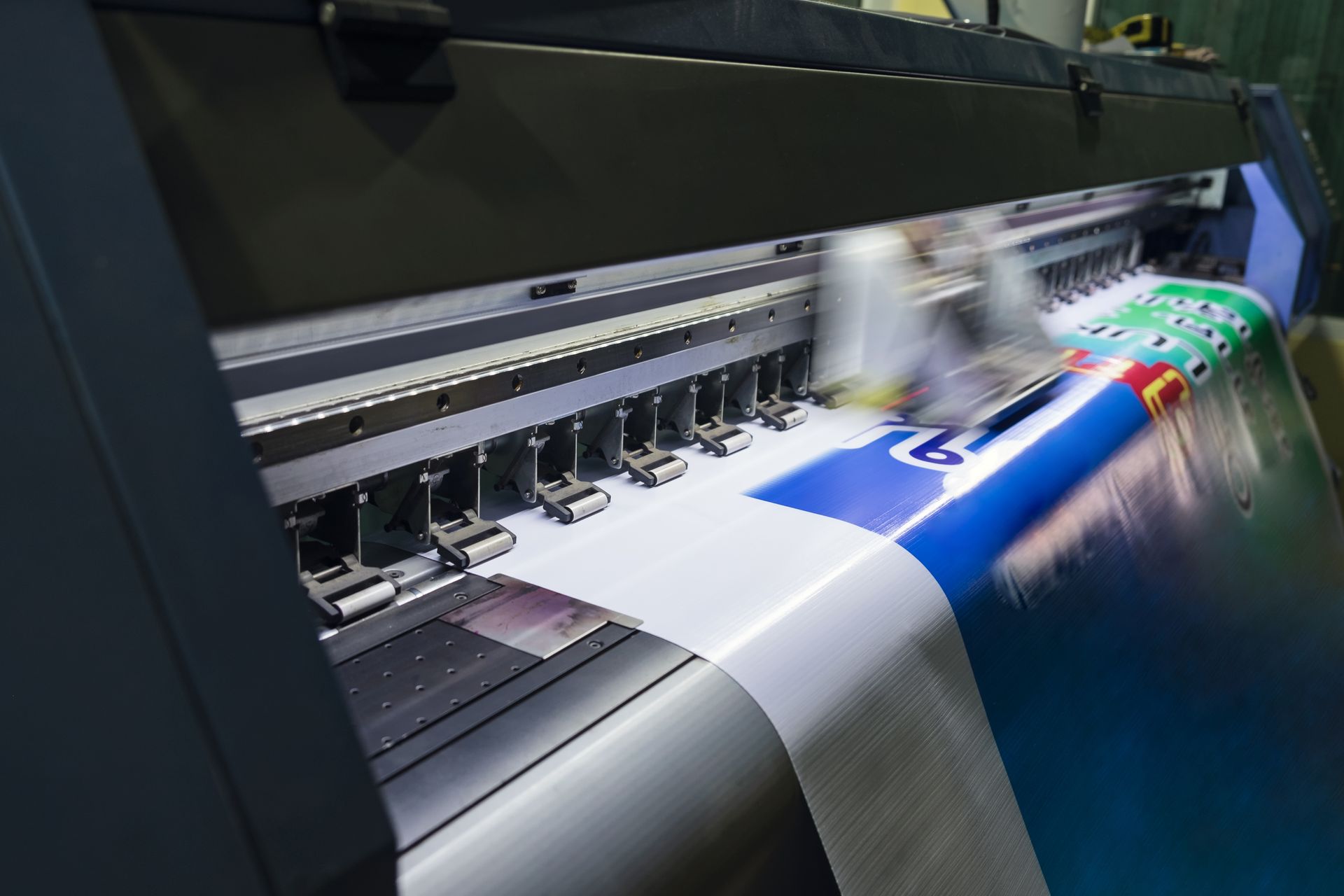 Large format printer printing a colorful banner.