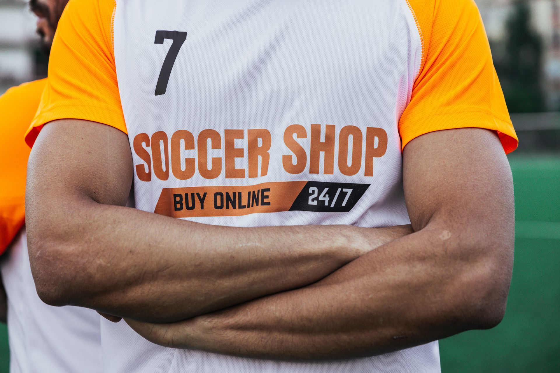 Person operating a heat press machine on a table. White t-shirts are being pressed in a room.