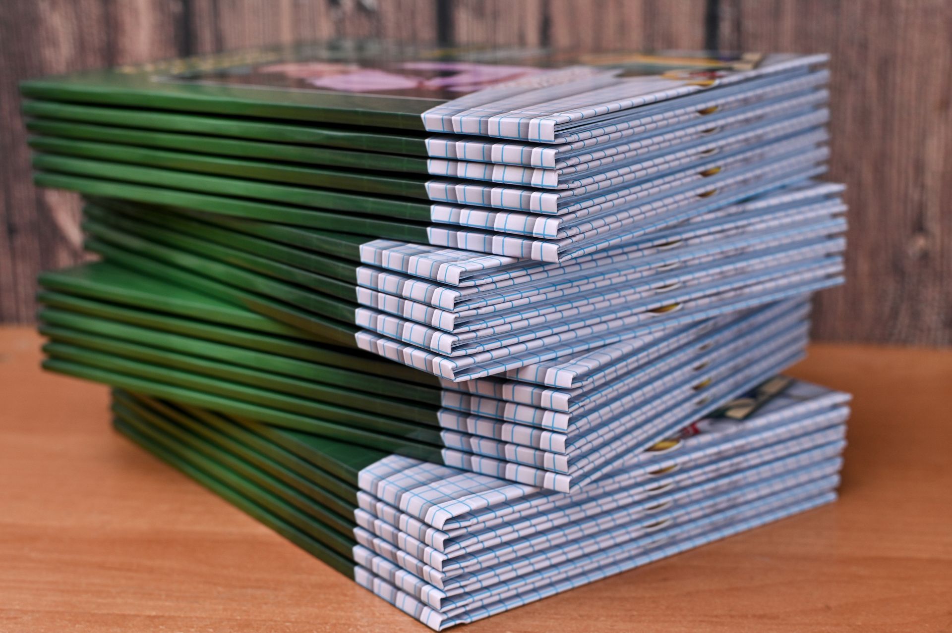 Man examining printed material with a magnifying glass in a printing facility.