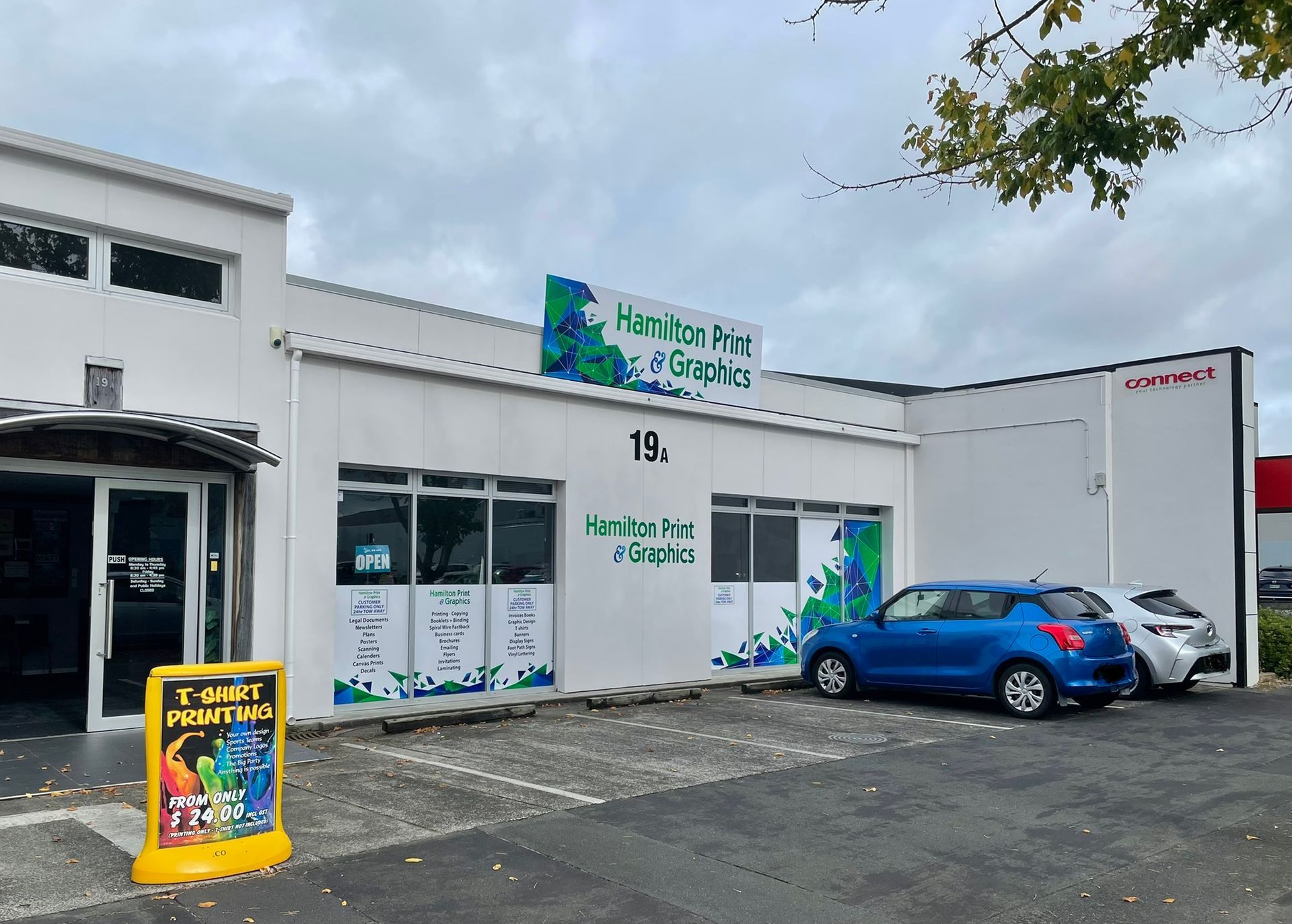 Exterior of Harbor Print & Graphics business with a blue car parked out front.