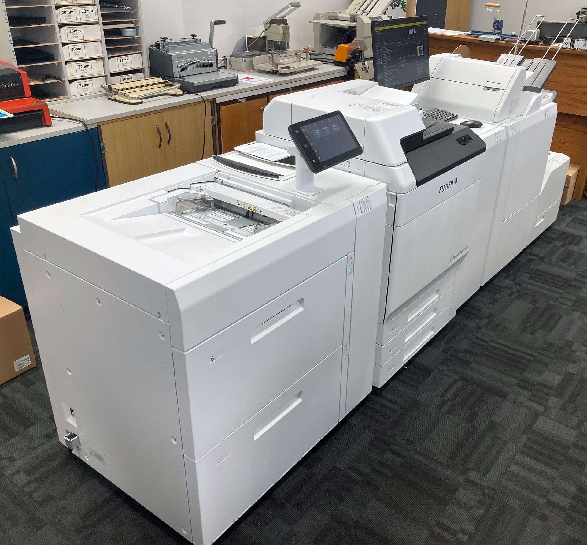 Large white office printer with touch screen interface and paper trays.