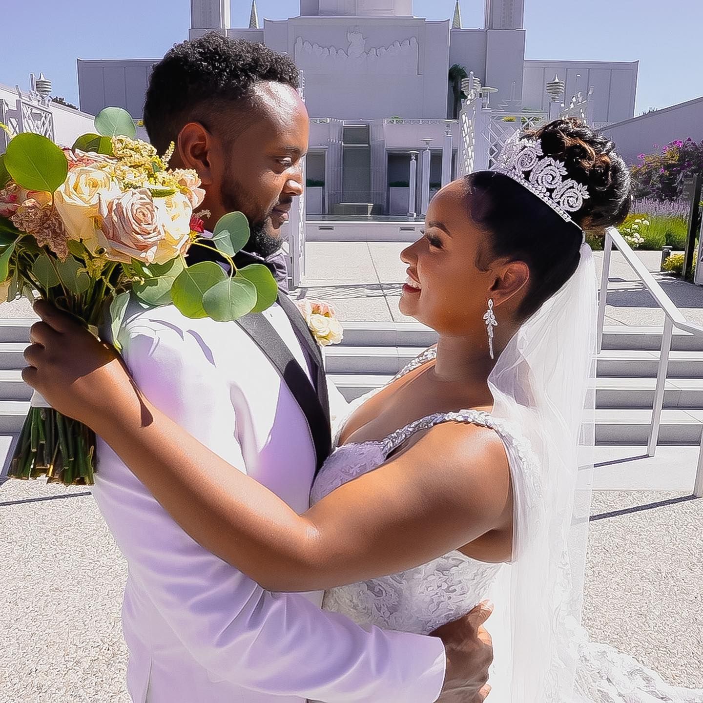 A bride and groom are posing for a picture in front of a church.