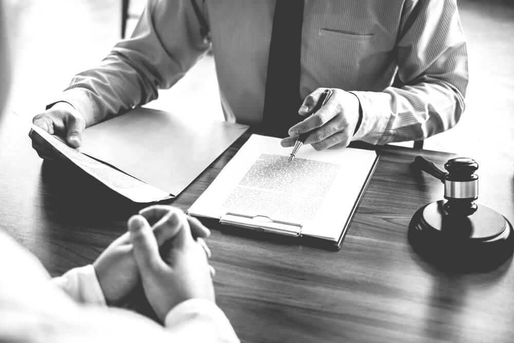 Consultation Between Businessman And Lawyer With A Gavel Placed On Table — Farrell Lusher Solicitors In Wagga Wagga, NSW