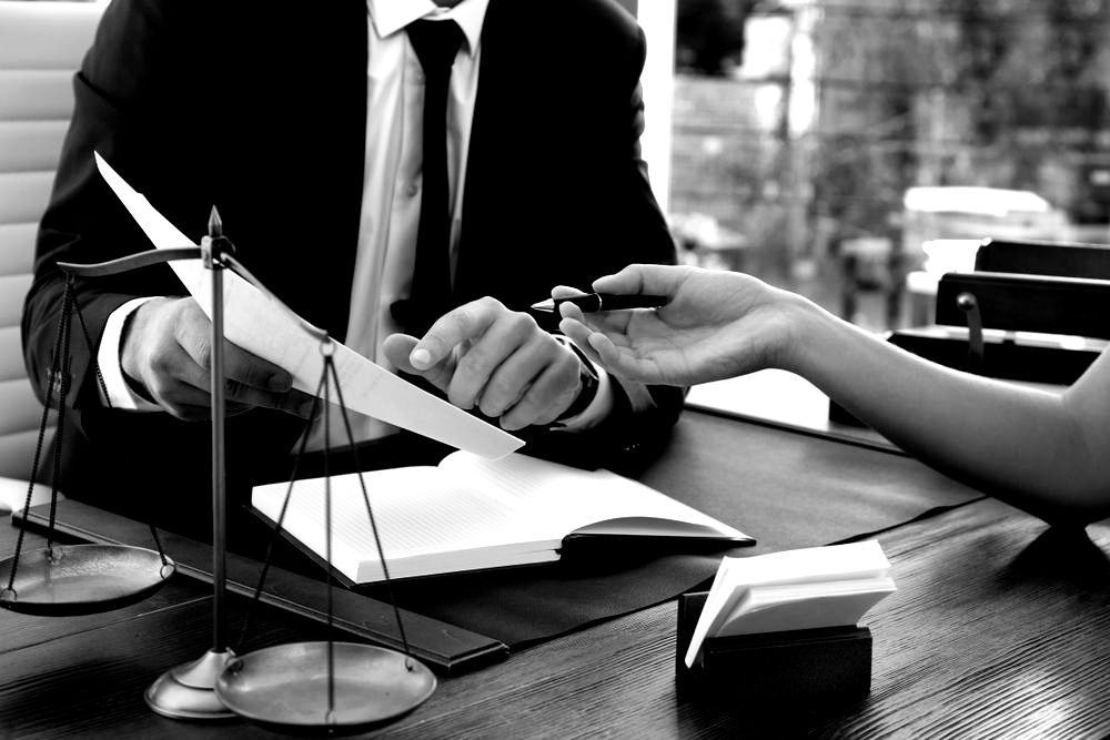 Lawyers Discussing Contract Papers Sitting At The Table — Farrell Lusher Solicitors In Wagga Wagga, NSW