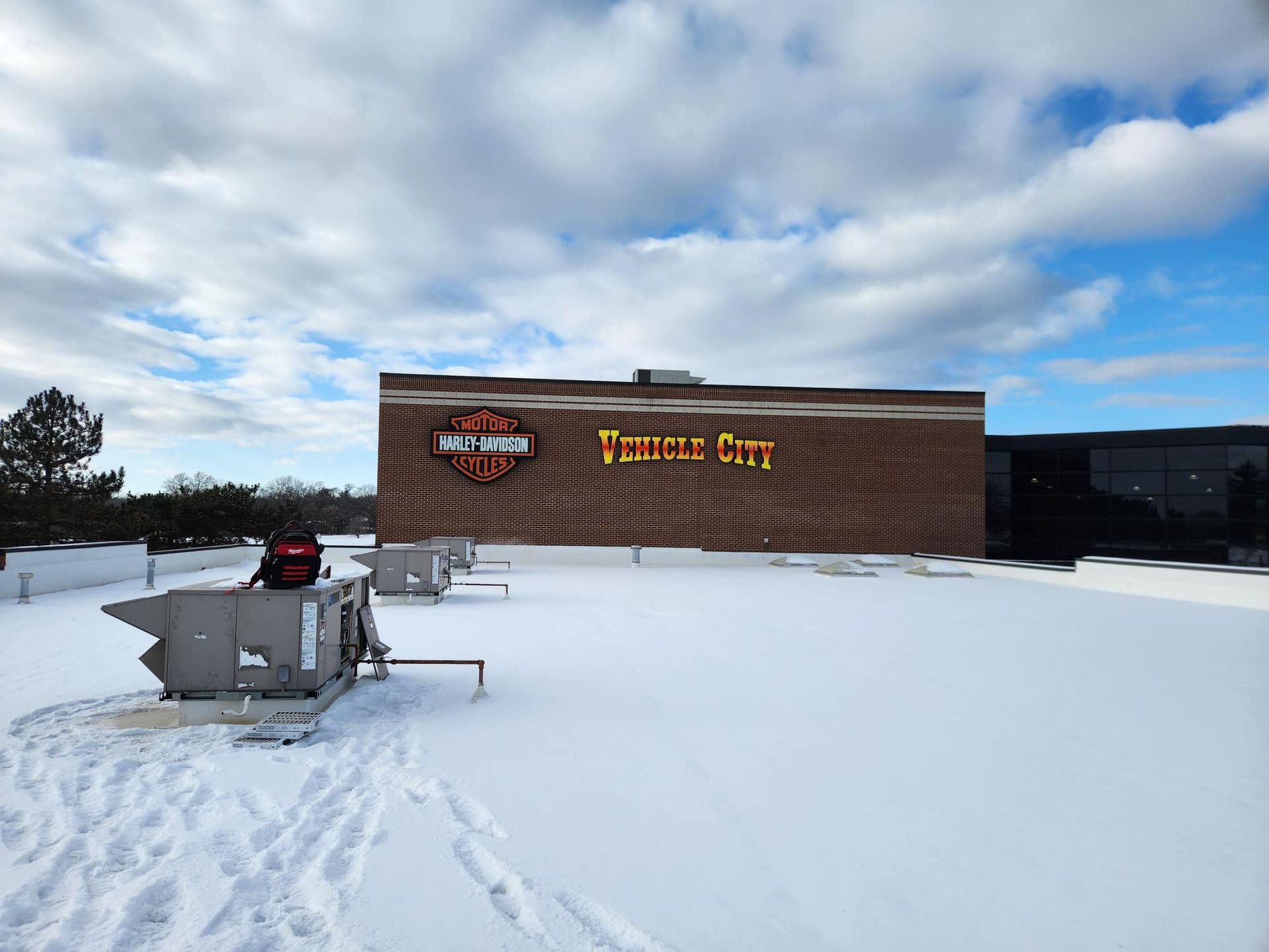 Cozy basement living area with two brown reclining sofas, stone wall, and air conditioning unit.