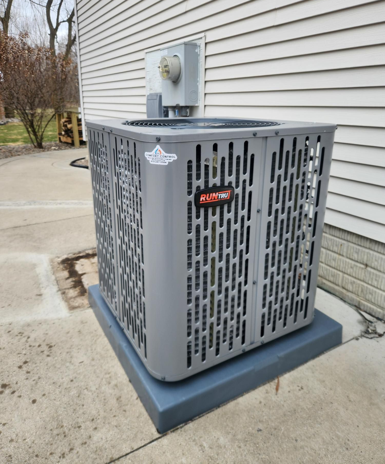 Furnace in a closet with white vents and pipes, against gray walls and white door.