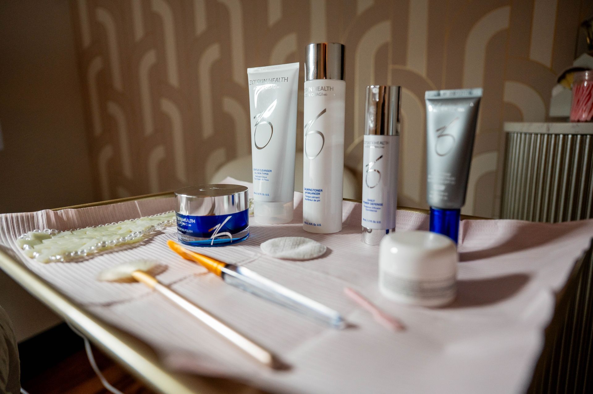 A table topped with a variety of cosmetics and brushes.