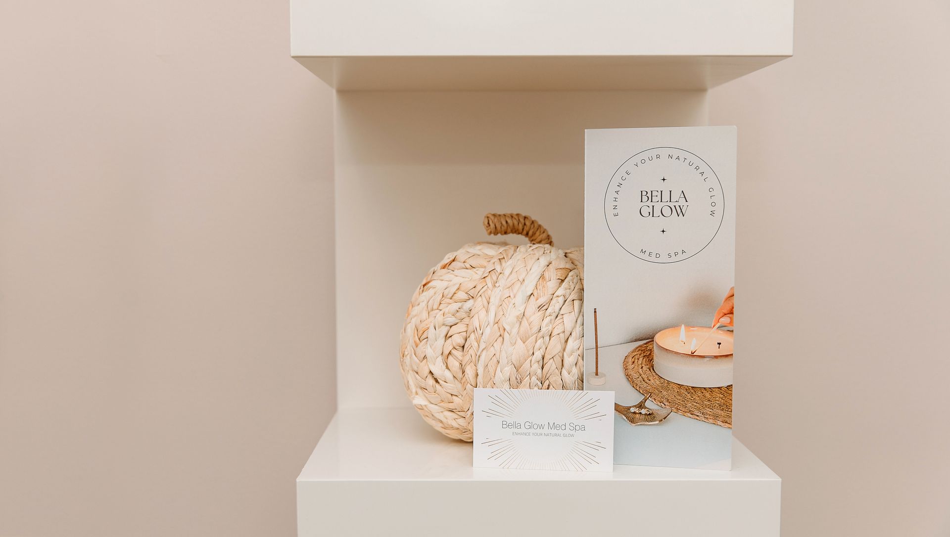 A white shelf with a pumpkin and a card on it.