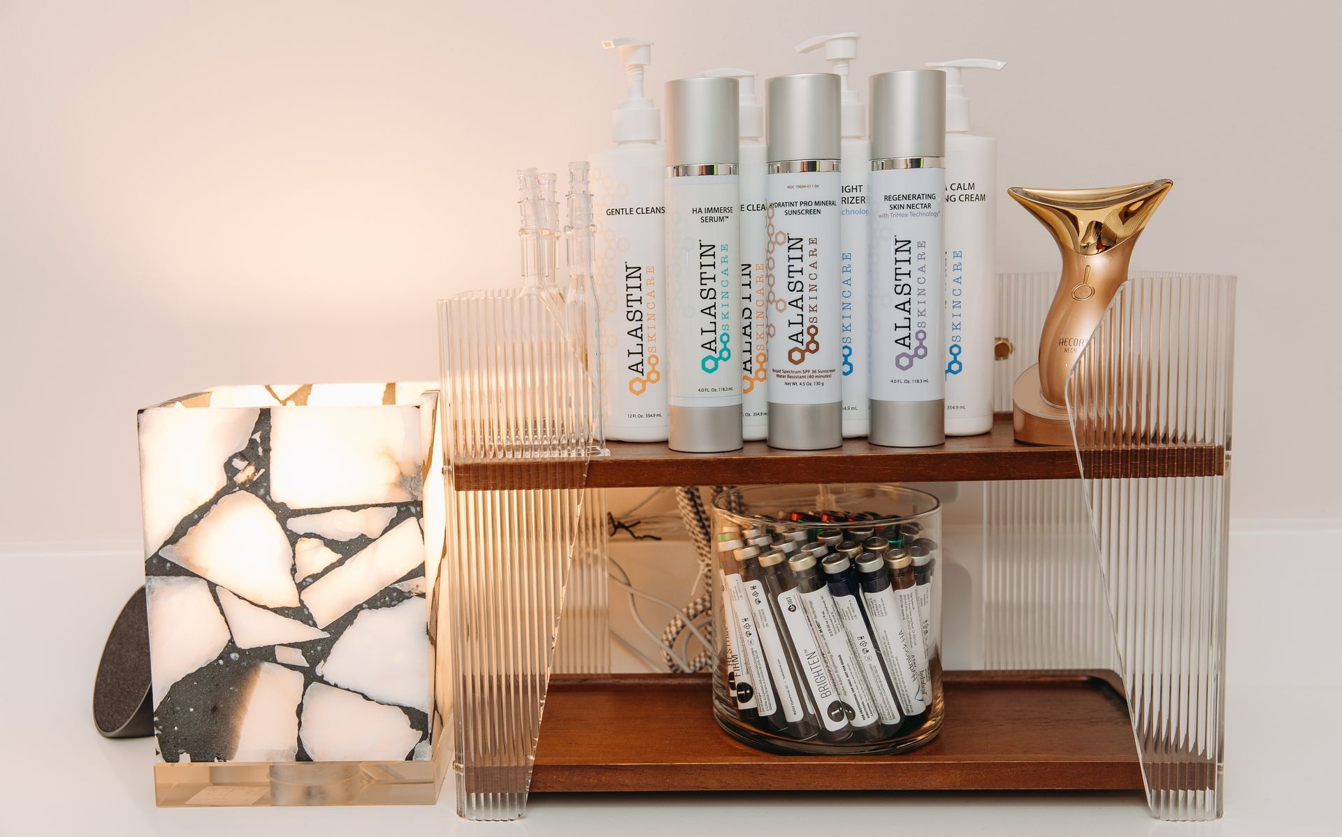 A shelf with bottles of lotion and candles on it