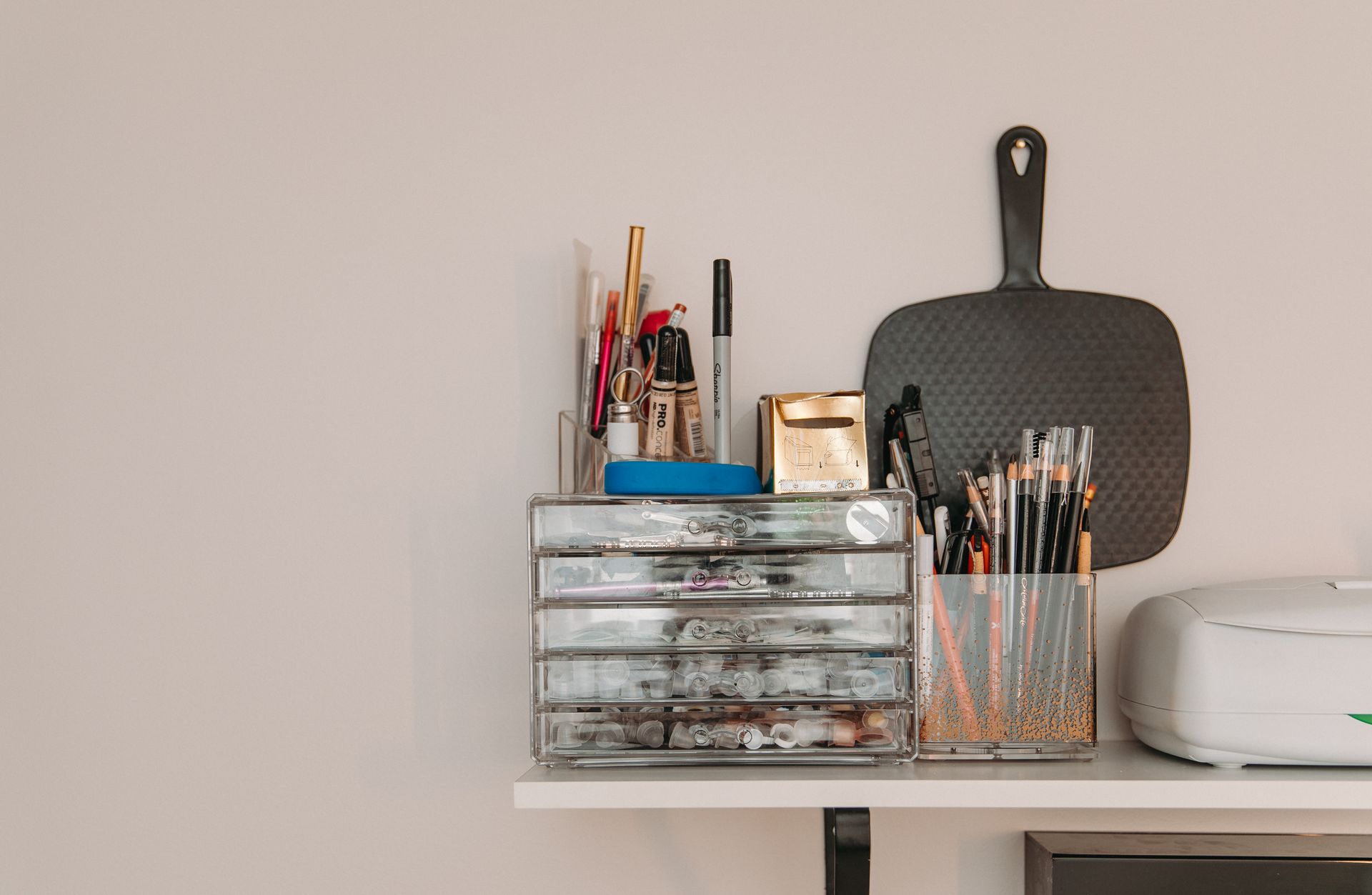 A shelf with a stack of drawers and a cutting board on it.