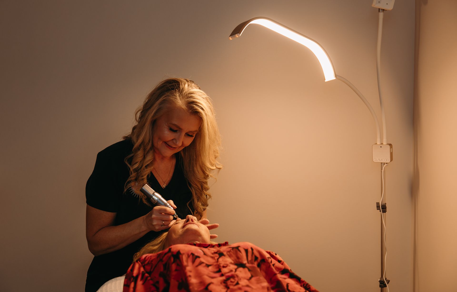 A woman is using a machine on a woman 's face in a beauty salon.