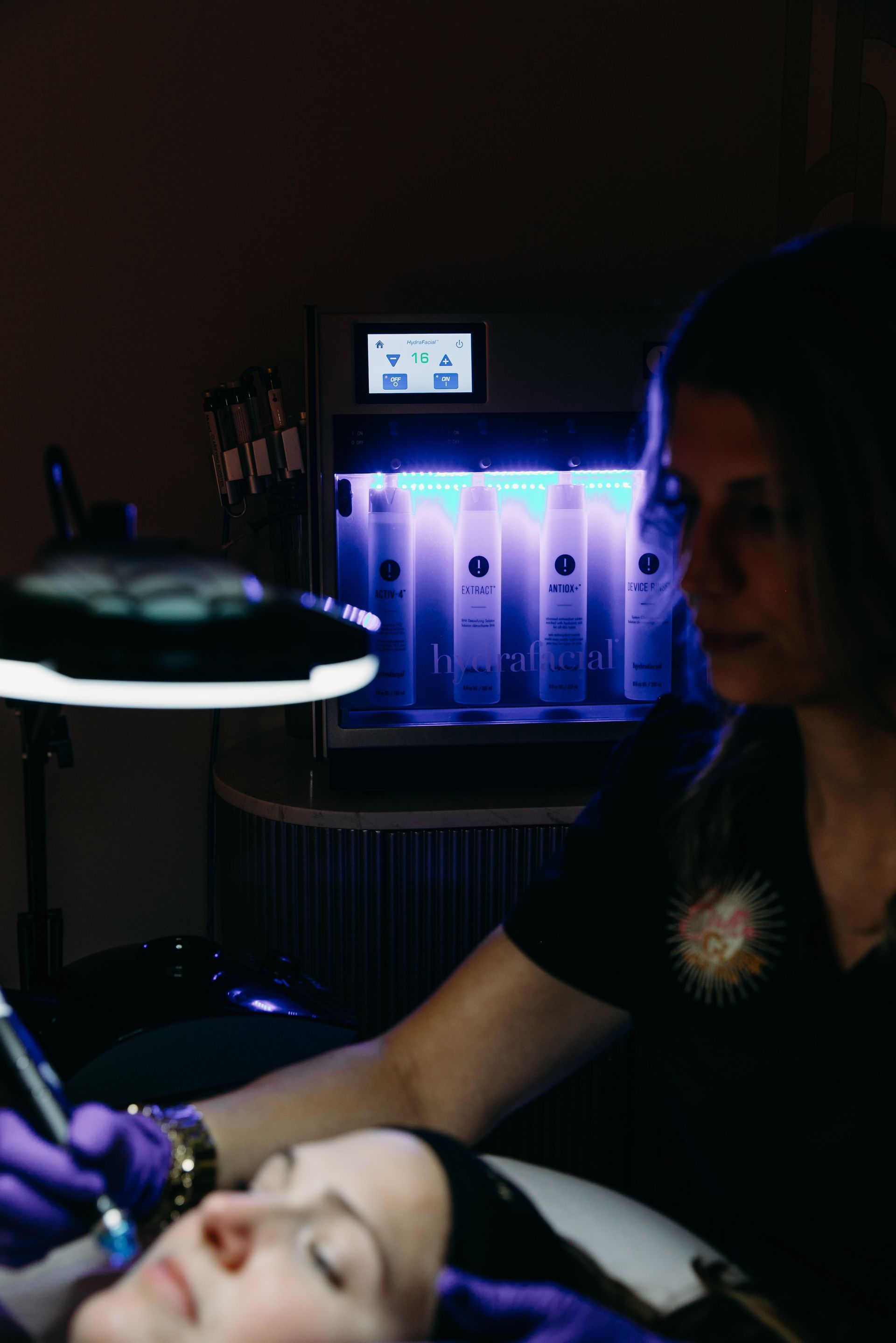 A woman is getting a treatment on her face in a beauty salon.